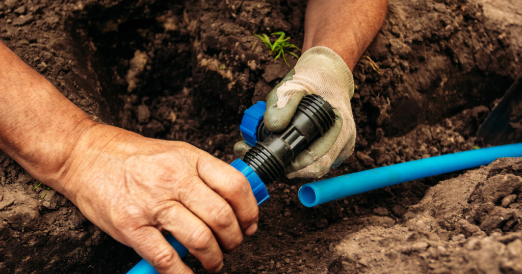 Man installing underground corporate irrigation systemm